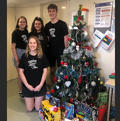 People around the tree and gifts
