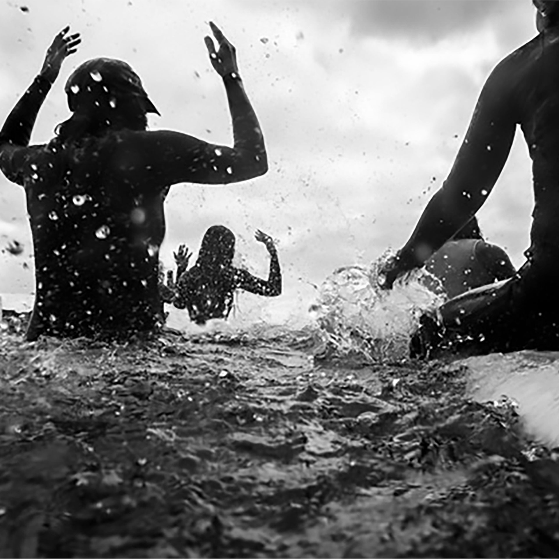 An artistic photo showing people sitting up on surfboards from behind