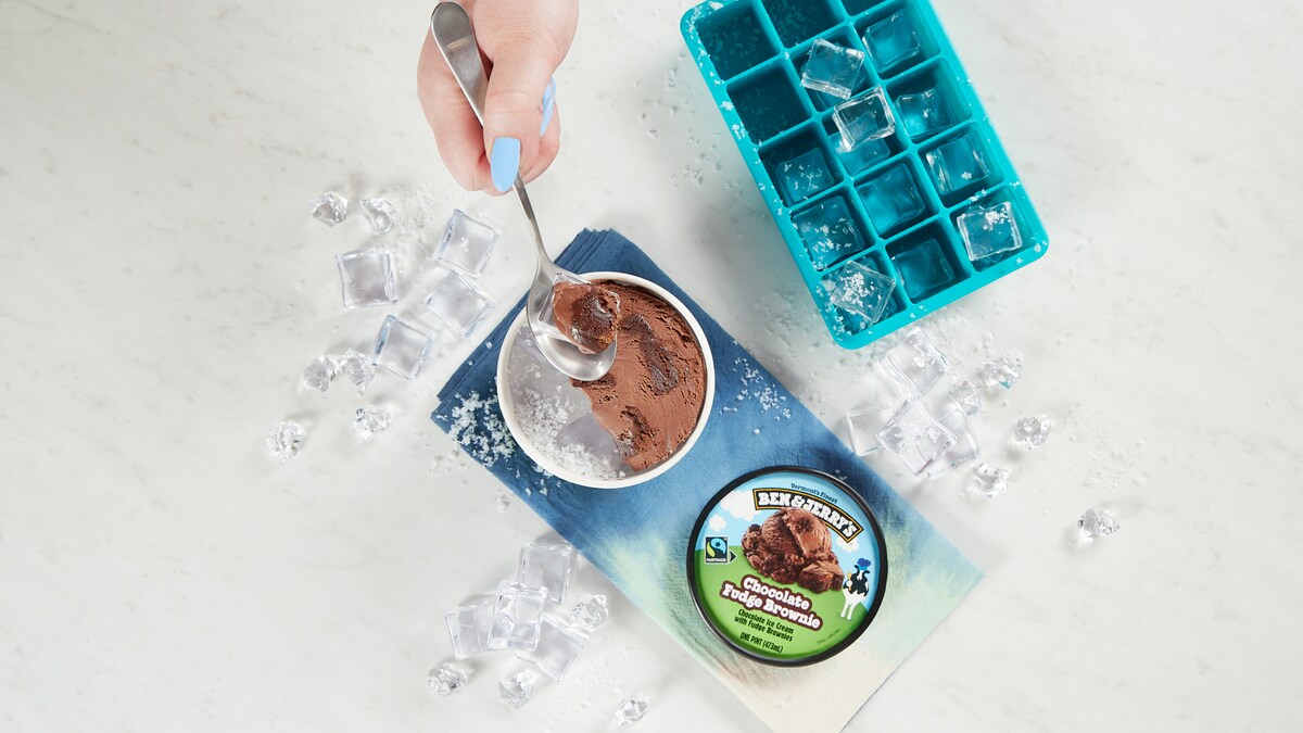 Hand taking a spoonful of ice cream from the top of the pint