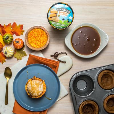 Pumpkin Cheesecake Ice Cream Bowl with Ben & Jerry's ice cream on top next to a pint of Ben & Jerry's Pumpkin Cheesecake ice cream.