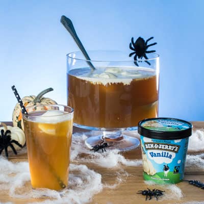 Punch bowl of Apple Pie À La Mode Punch next to a pint glass of Apple Pie À La Mode Punch and a pint of Ben & Jerry's Vanilla ice cream.