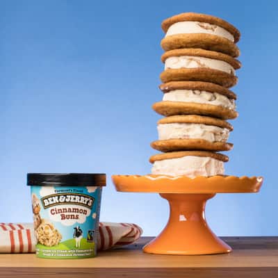 Stack of Snickerdoodle Ice Cream Sammies on a pedestal next to a pint of Ben & Jerry's Cinnamon Buns ice cream.