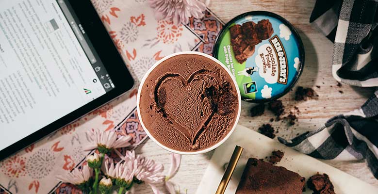 Ben & Jerry's Chocolate Fudge Brownie in a cozy setting with a heart carved into the top of the ice cream.